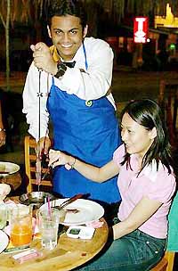 Cards on the table tell the passador (above) if you want seconds. He will then carve the meat or fish at your table.
